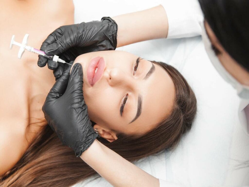 Cosmetologist does kybella therapy of a beautiful woman in a beauty salon. Cosmetology concept. | Lily Med Spa in Dallas, Texas