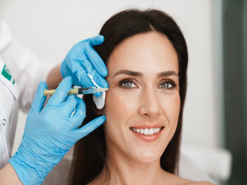 Beautiful face Botox injection Cosmetic skincare spa beauty treatment with blue gloves by eye, | Lily Med Spa in Dallas, Texas
